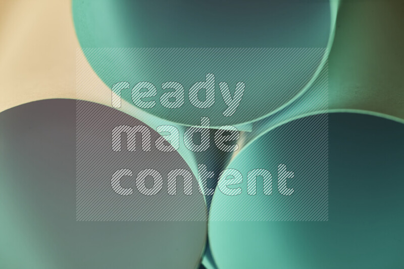 الصورة تعرض فن ورقي تجريدي بأشكال دائرية بدرجات متنوعة من اللون الأخضر والدرجات الدافئة