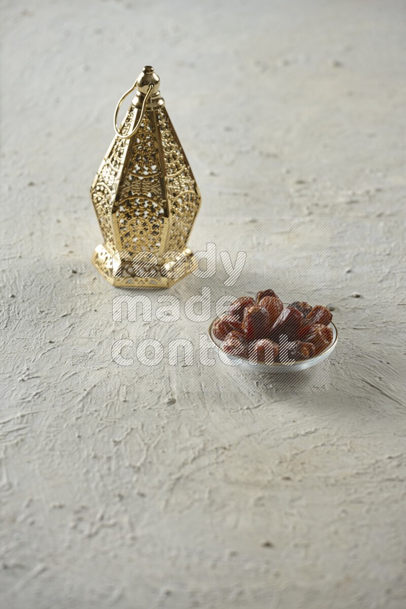 A golden lantern with different drinks, dates, nuts, prayer beads and quran on textured white background