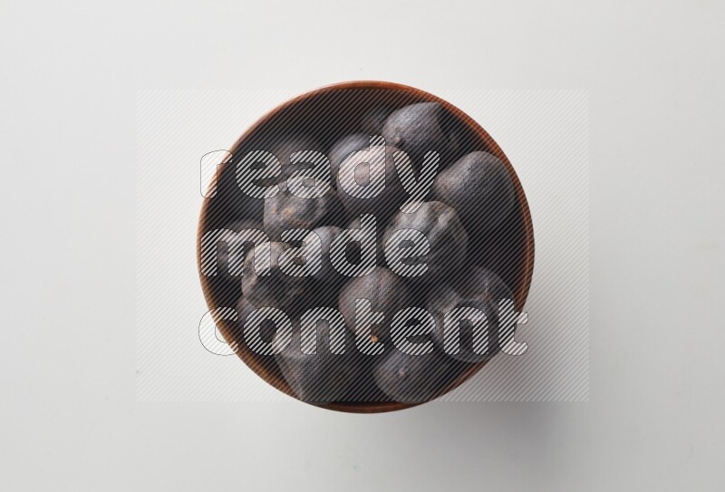 Top-view shot of dried lime (loomi) in a container on white background