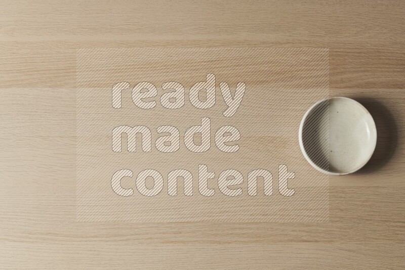 وعاء فخاري أبيض على خلفية خشبية فاتحة