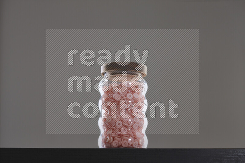 Buttons in a glass jar on black background