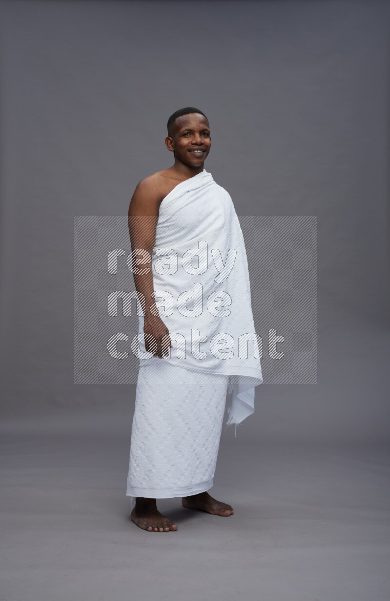 A man wearing Ehram Standing Interacting with the camera on gray background