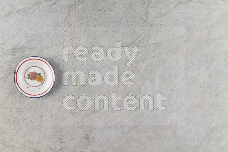 صحن معدني عتيق على خلفية من الرخام الرمادي