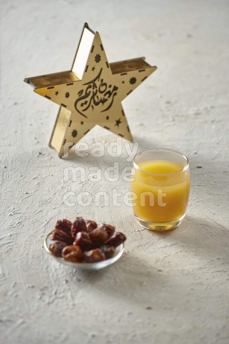 A wooden golden star lantern with different drinks, dates, nuts, prayer beads and quran on textured white background