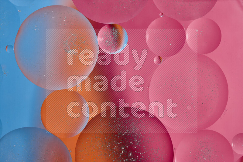 Close-ups of abstract oil bubbles on water surface in shades of blue, orange and pink