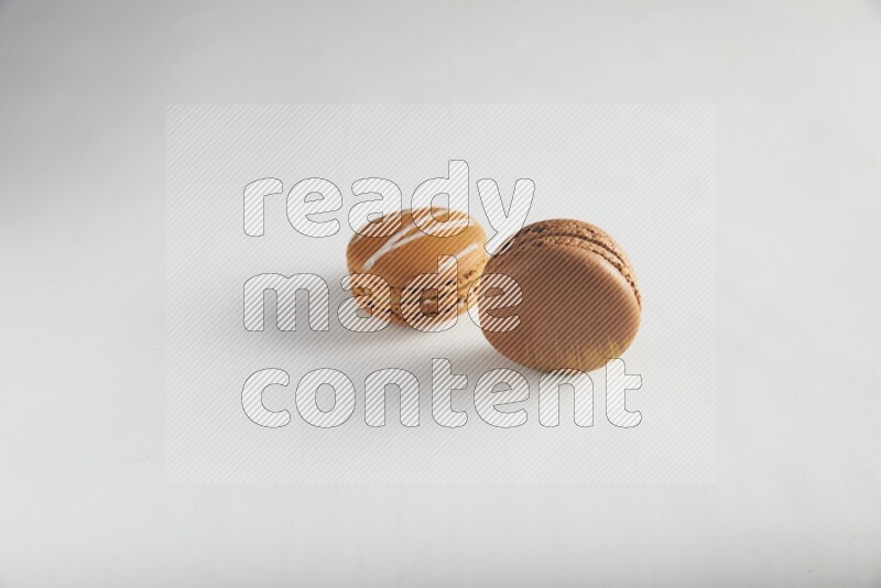 45º Shot of of two assorted Brown Irish Cream, and Brown Coffee macarons  on white background