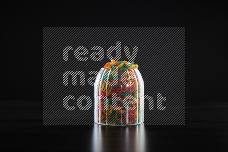 Snacks in a glass jar on black background