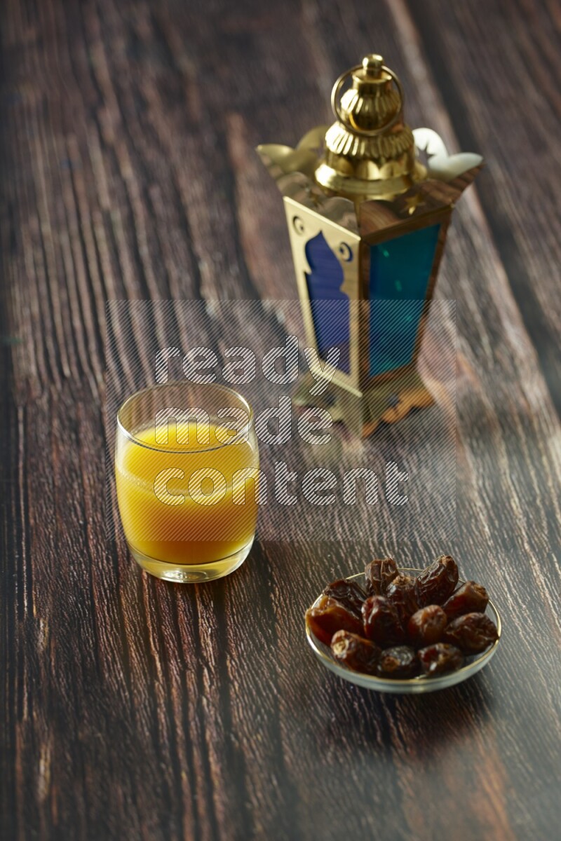 A golden lantern with different drinks, dates, nuts, prayer beads and quran on brown wooden background