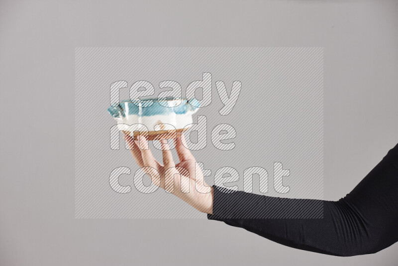 A woman in black abaya holding different pottery essentials in different positions