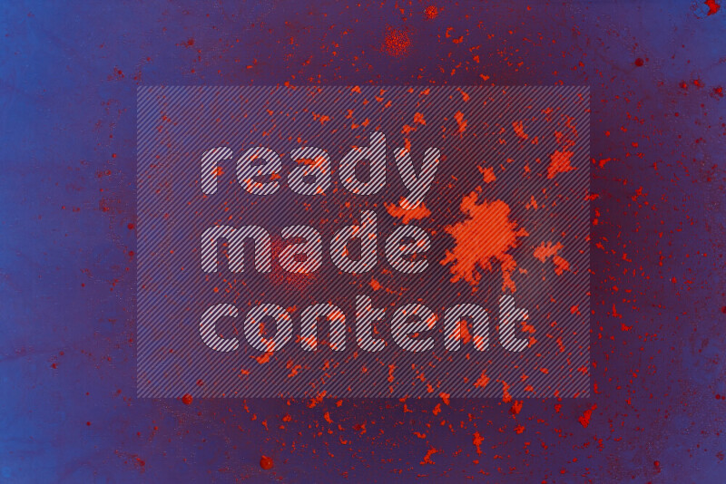 The image captures a dramatic splatter of red paint over a blue backdrop