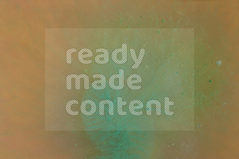 The image captures a dramatic splatter of green paint over a orange backdrop