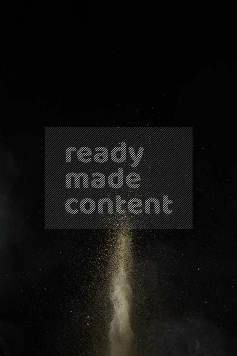A side view of yellow powder explosion on black background