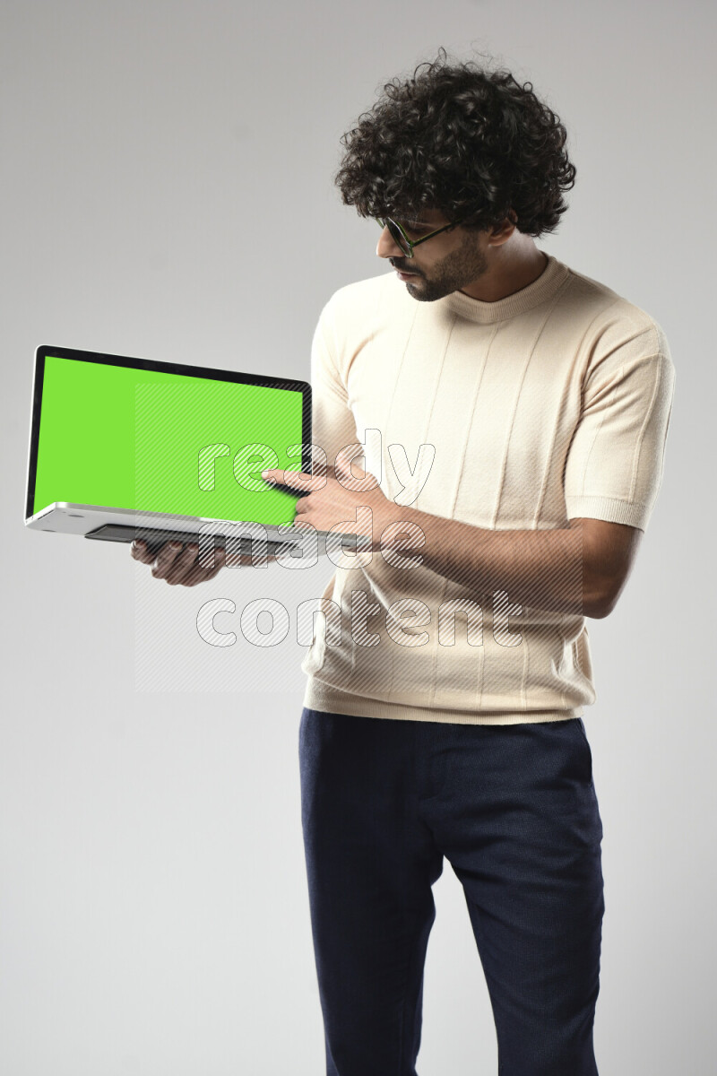 A man wearing casual standing and showing a laptop screen on white background