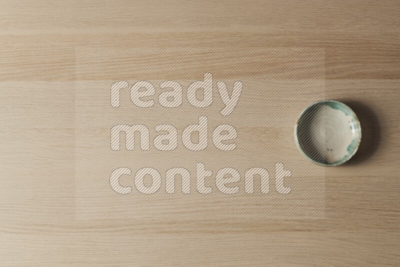 A multicolored pottery bowl on light wooden background