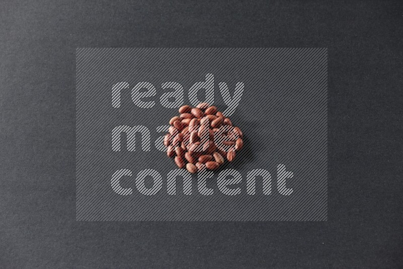 A bunch of red skin peanuts on a black background in different angles