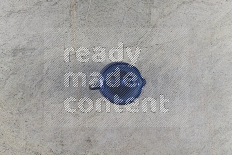 A colored glass jug on grey marble background