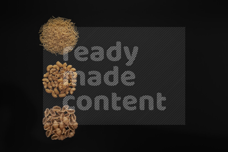 Different pasta types in 3 bunches on black background