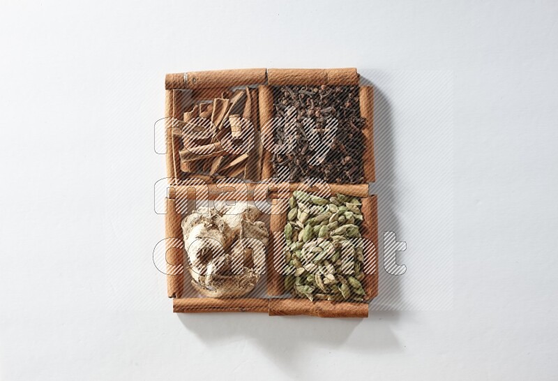 4 squares of cinnamon sticks full of cardamom, cinnamon, cloves and dried ginger on white flooring