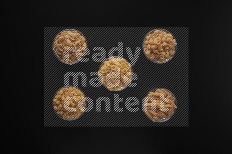 أنواع مختلفة من المعكرونة في أوعية زجاجية علي خلفية سوداء