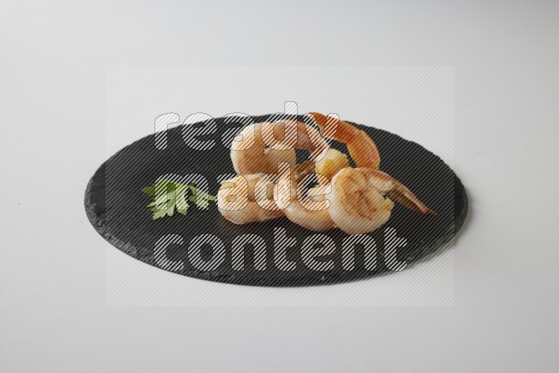 five grilled shrimps  on a black slate direct  on a white back ground