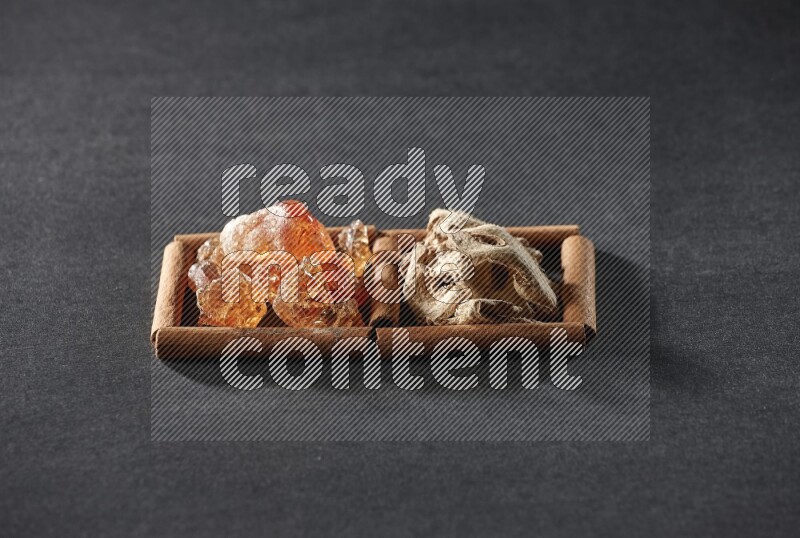 مربعان من أعواد القرفة ممتلئان بالزنجبيل المجفف والصمغ العربي علي خلفية سوداء