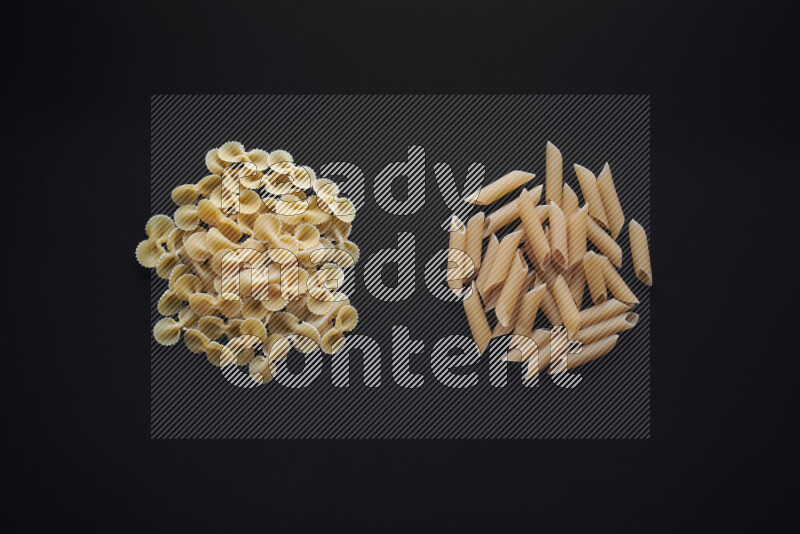 Different pasta types in bunches on black background