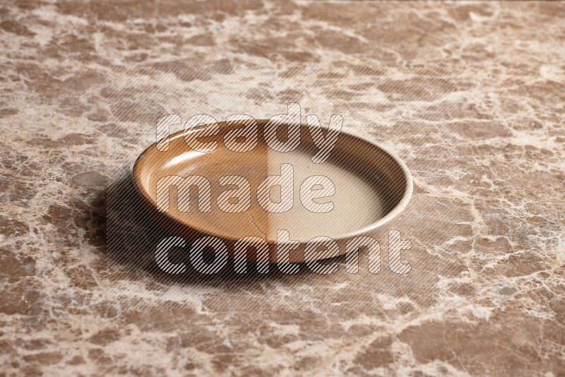 A multicolored pottery oven plate on beige marble background