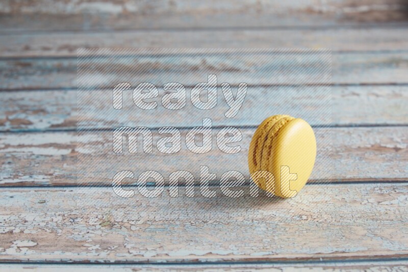 45º Shot of Yellow Lemon macaron on light blue wooden background