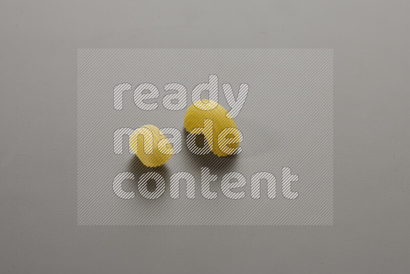 Big rings pasta with other types of pasta on grey background