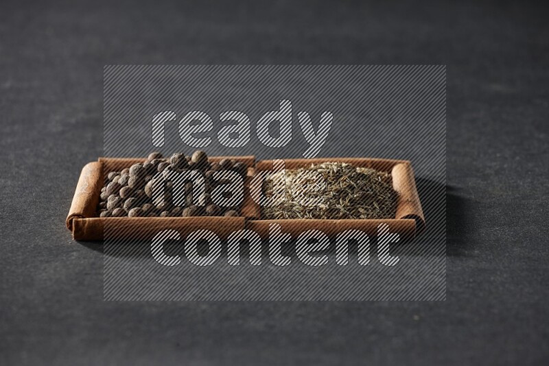 2 squares of cinnamon sticks full of cumin and allspice on black flooring