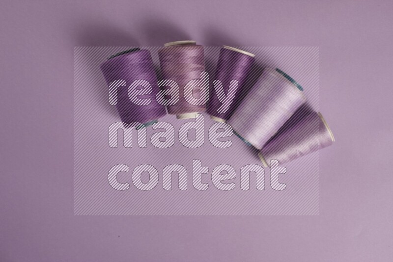 مجموعة من أدوات الخياطة والتفصيل أرجوانية اللون على خلفية أرجوانية