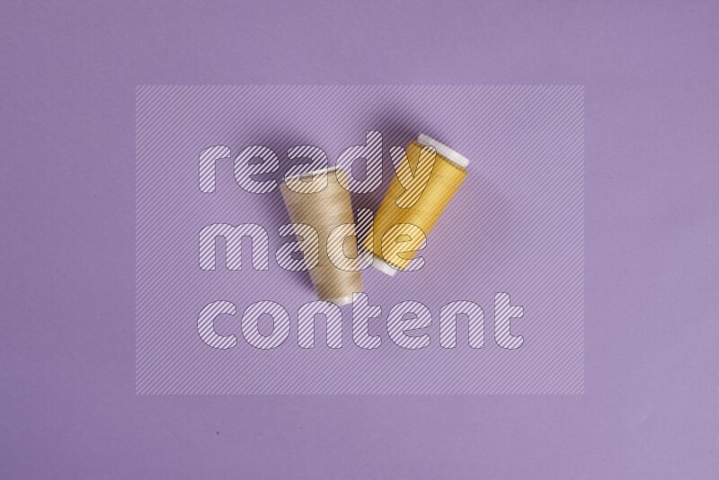 A yellow and purple collection of sewing and tailoring tools arranged on a purple background