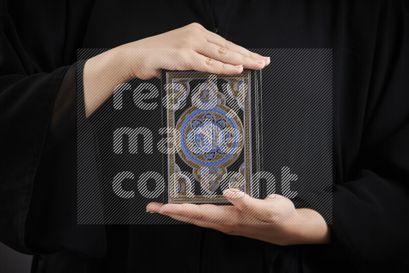 A woman hands holding moshaf in different positions
