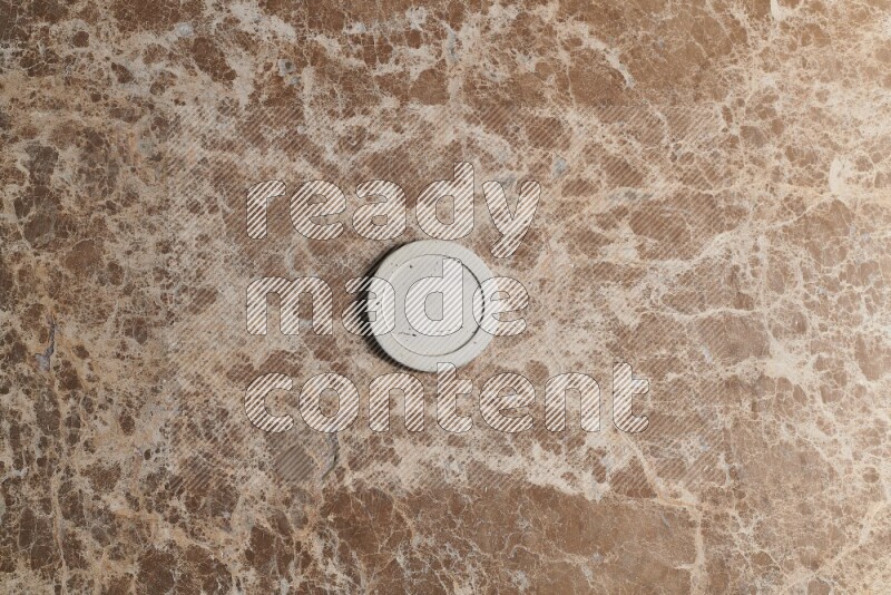 A decorative coaster on beige marble background