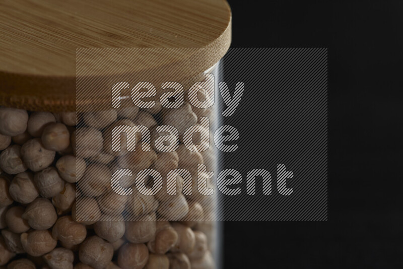 Chickpeas in a glass jar on black background