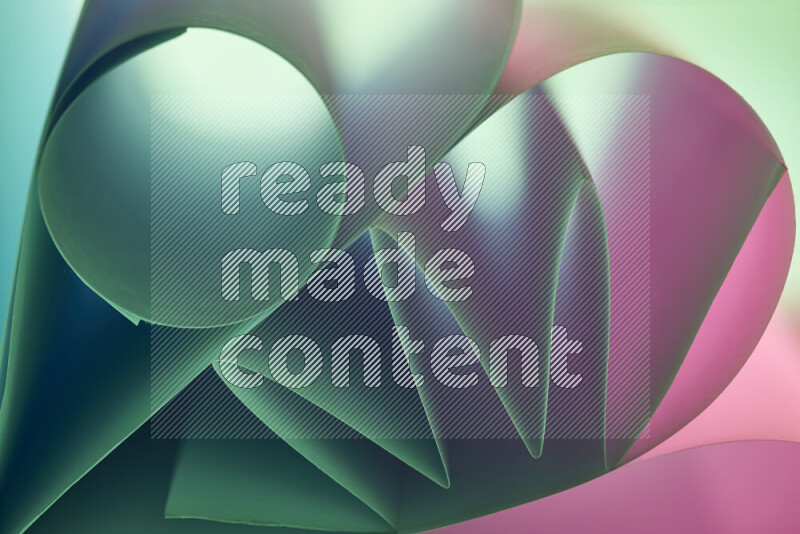 An artistic display of paper folds creating a harmonious blend of geometric shapes, highlighted by soft lighting in green and pink tones