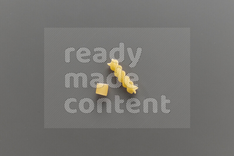 Big rings pasta with other types of pasta on grey background