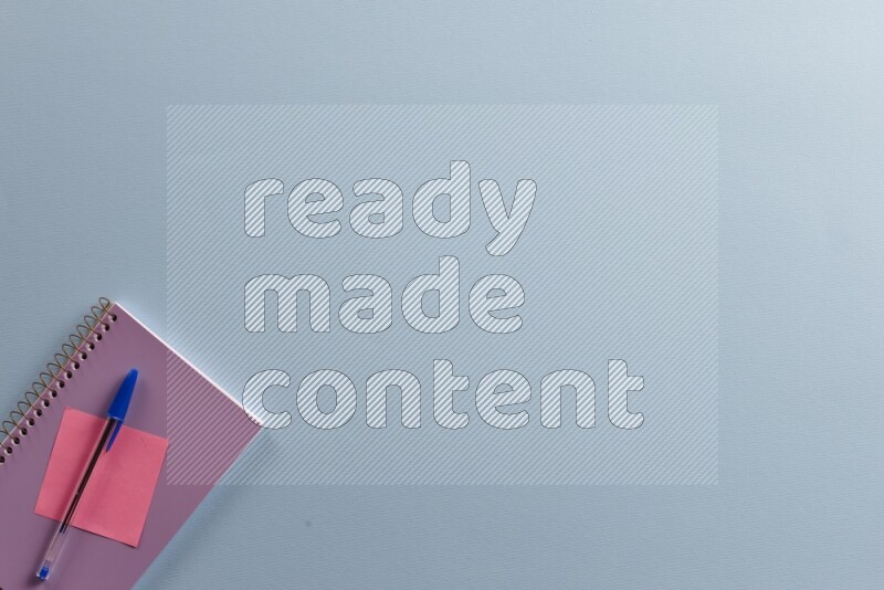 دفتر ملاحظات أرجواني مع مستلزمات مدرسية مختلفة على خلفية زرقاء