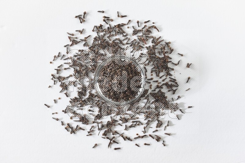 وعاء زجاجي ممتلئ بالقرنفل على أرضية بيضاء