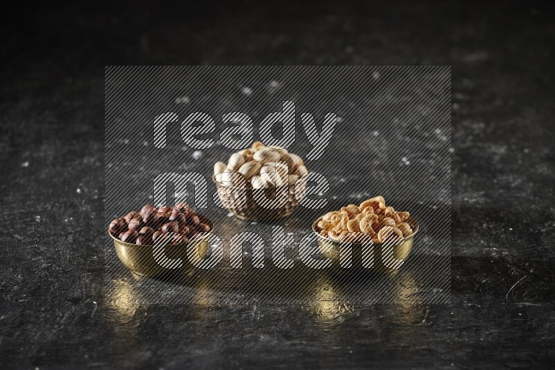 Nuts in a metal bowl in a dark setup