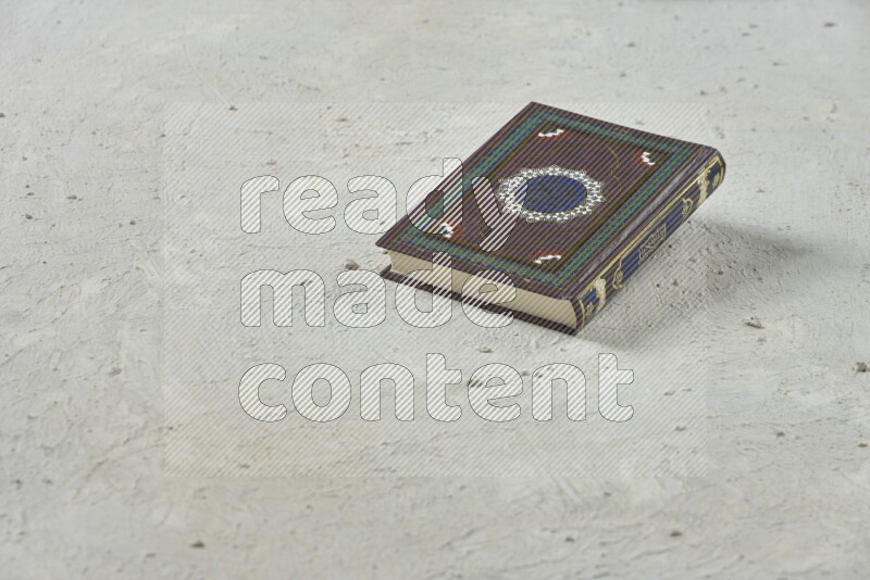 Quran with a prayer beads on white background