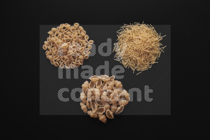 Different pasta types in bunches on black background