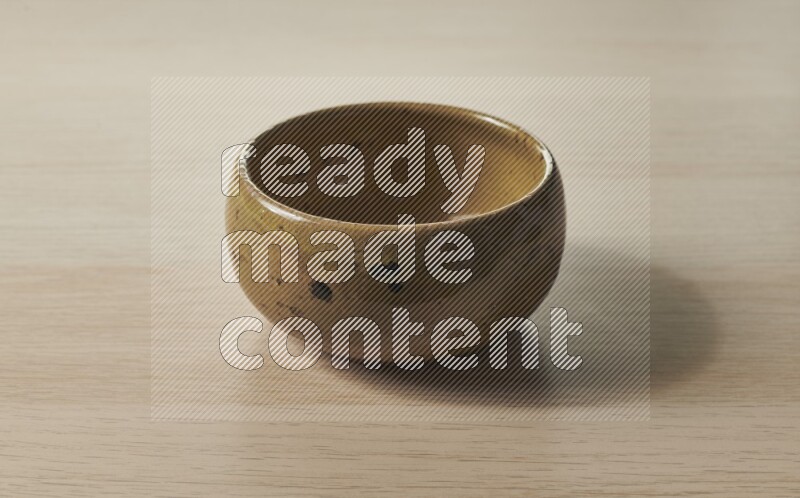 A multicolored pottery bowl on light wooden background