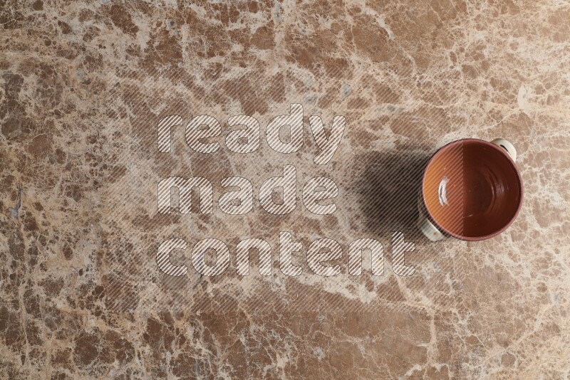 A multicolored pottery pot on beige marble background