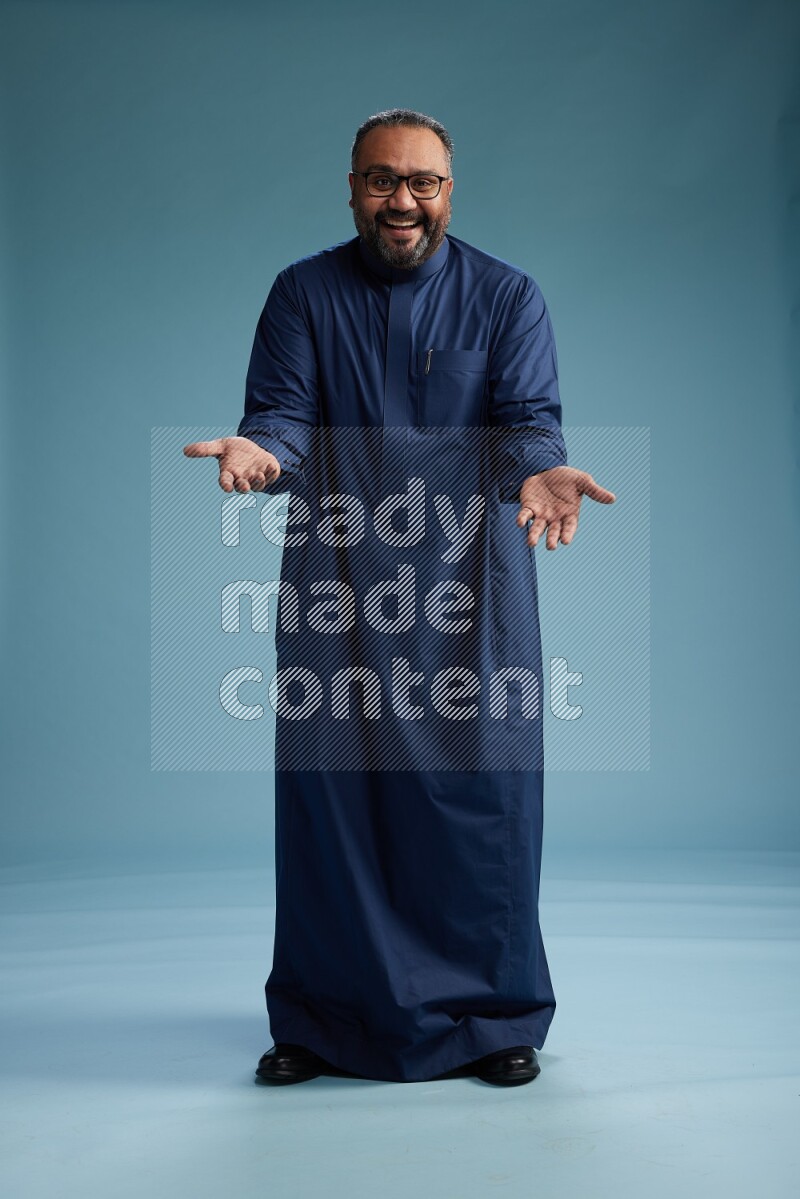 Saudi Man without shimag Standing Interacting with the camera on blue background