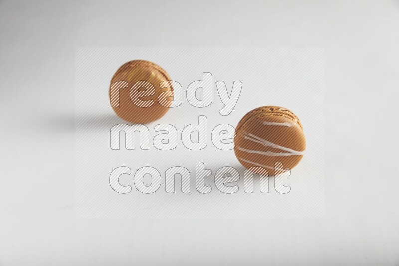 45º Shot of of two assorted Brown Irish Cream, and Brown Coffee macarons  on white background
