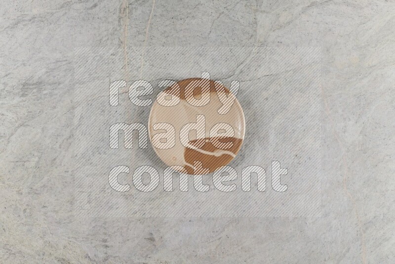 A multicolored pottery plate on grey marble background