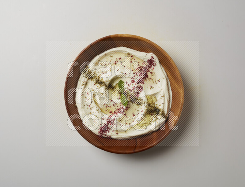 Lebnah garnished with  zattar , sumak & mint in a wooden plate on a white background
