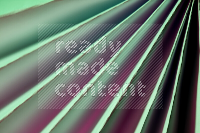 An image presenting an abstract paper pattern of lines in green and pink tones