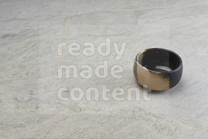 A multicolored pottery bowl on grey marble background